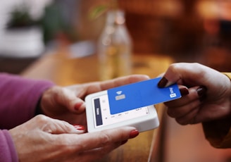 a person holding a credit card and a cell phone