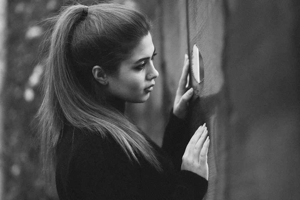 une photo en noir et blanc d’une femme accrochée à un mur