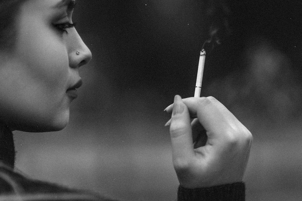 a woman smoking a cigarette in a black and white photo