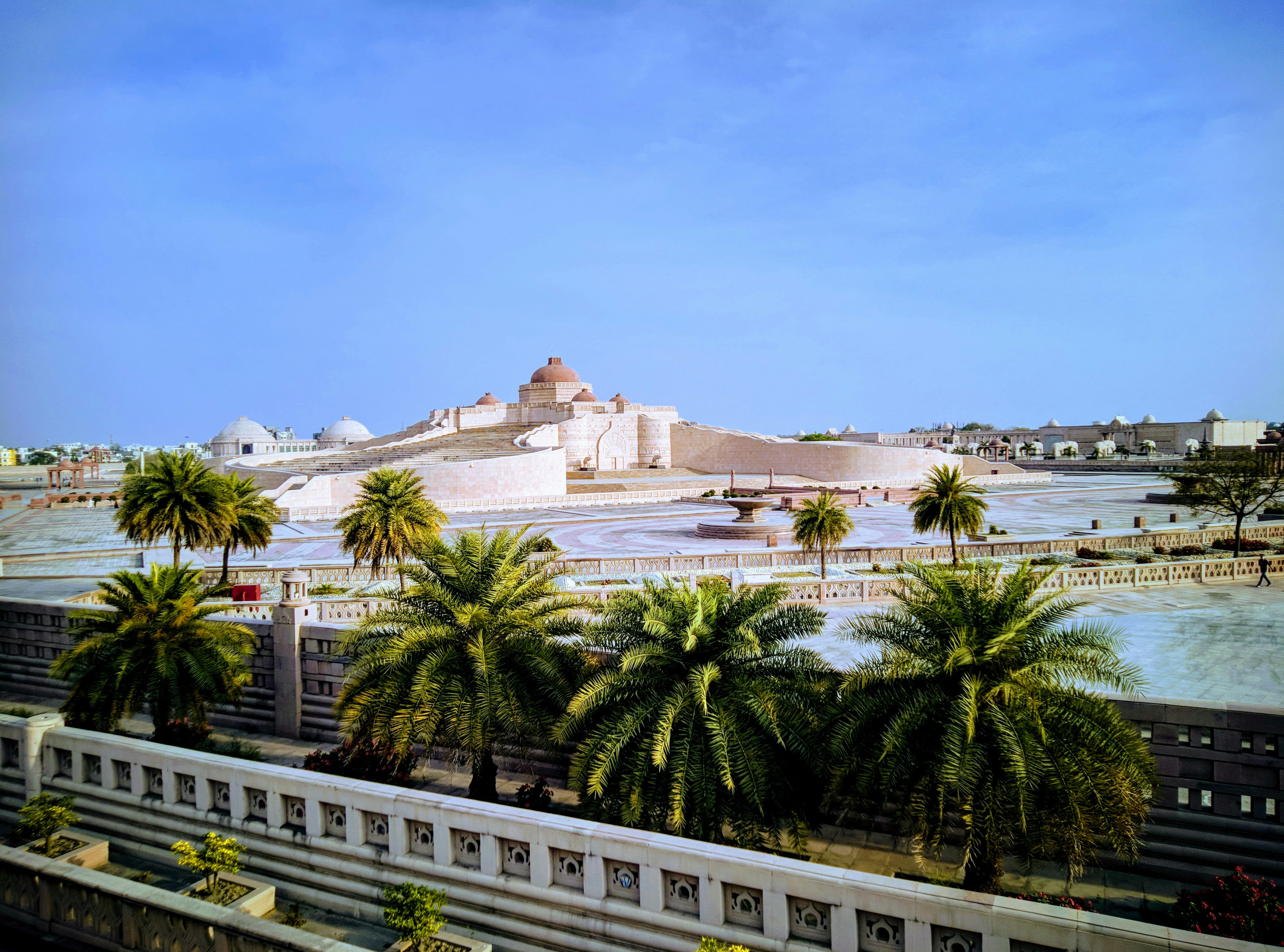 A view of a city with palm trees and a castle in the background photo ...
