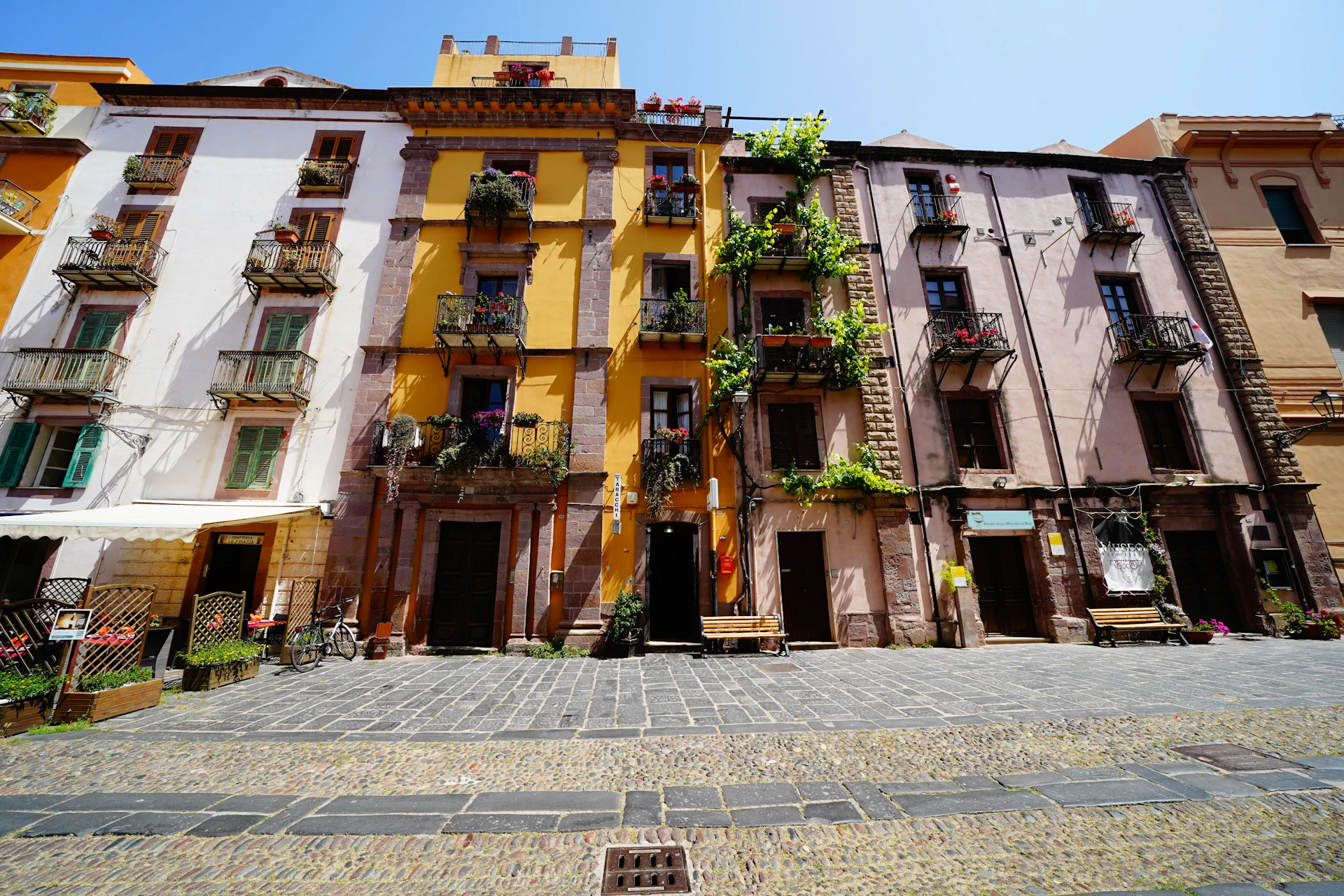 A charming street scene in a historic Balkan town with colorful buildings and cobblestone paths.