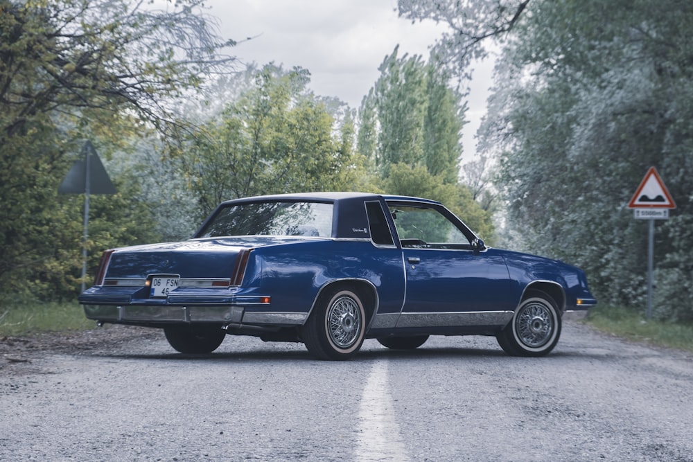 a blue car parked on the side of a road