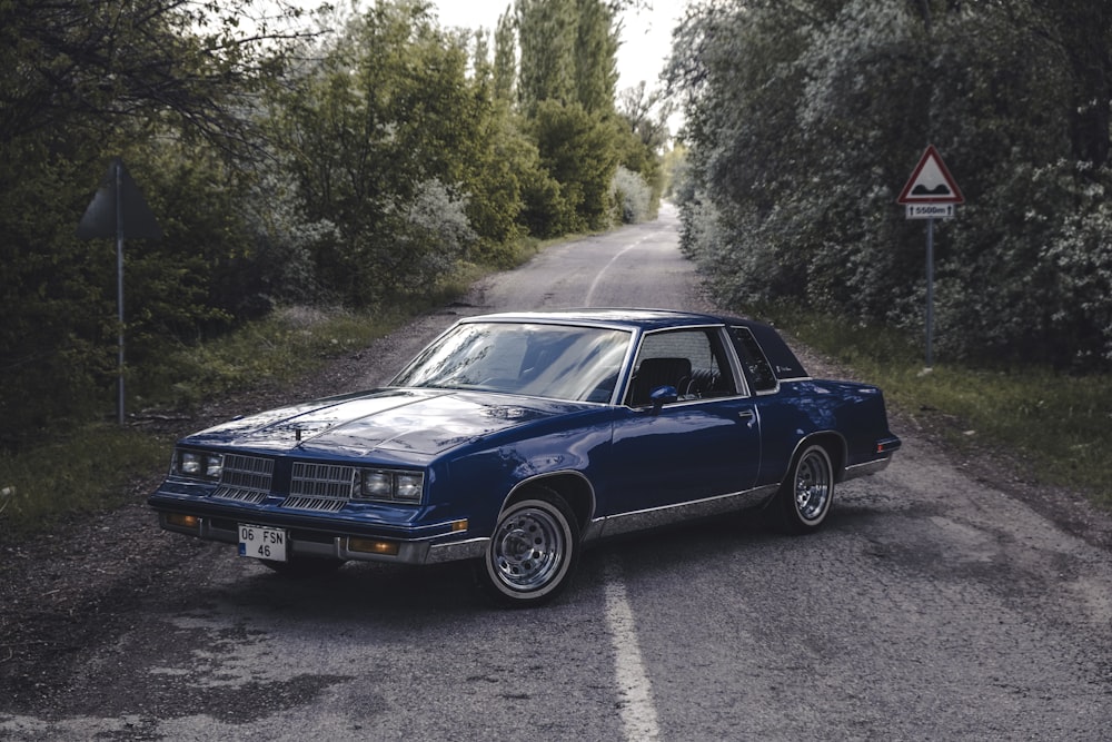 a blue car parked on the side of a road