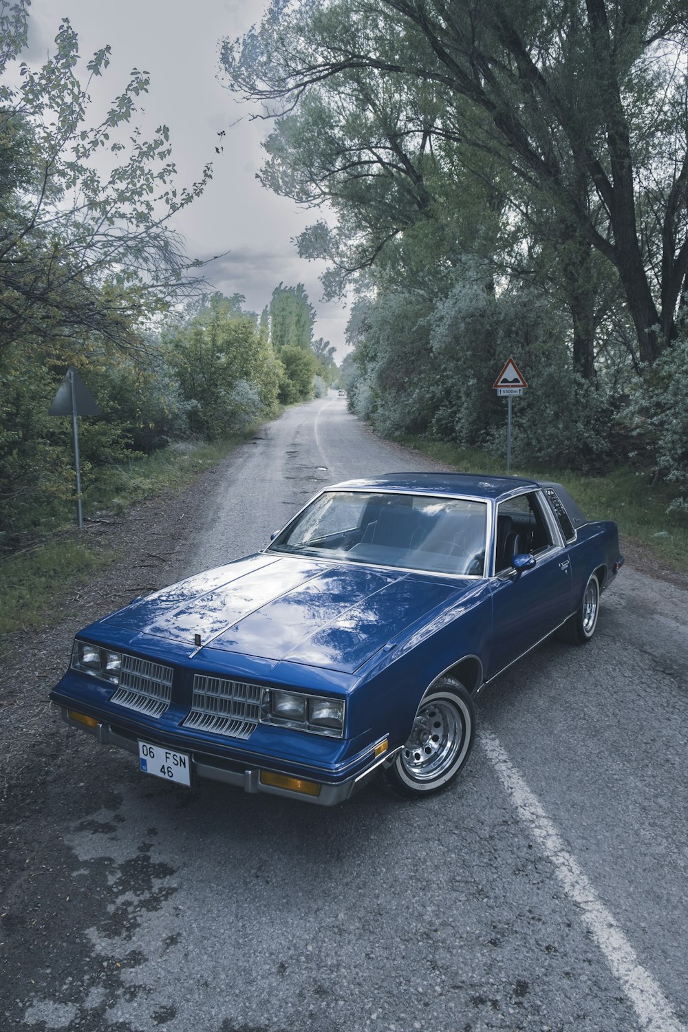 a blue car parked on the side of a road