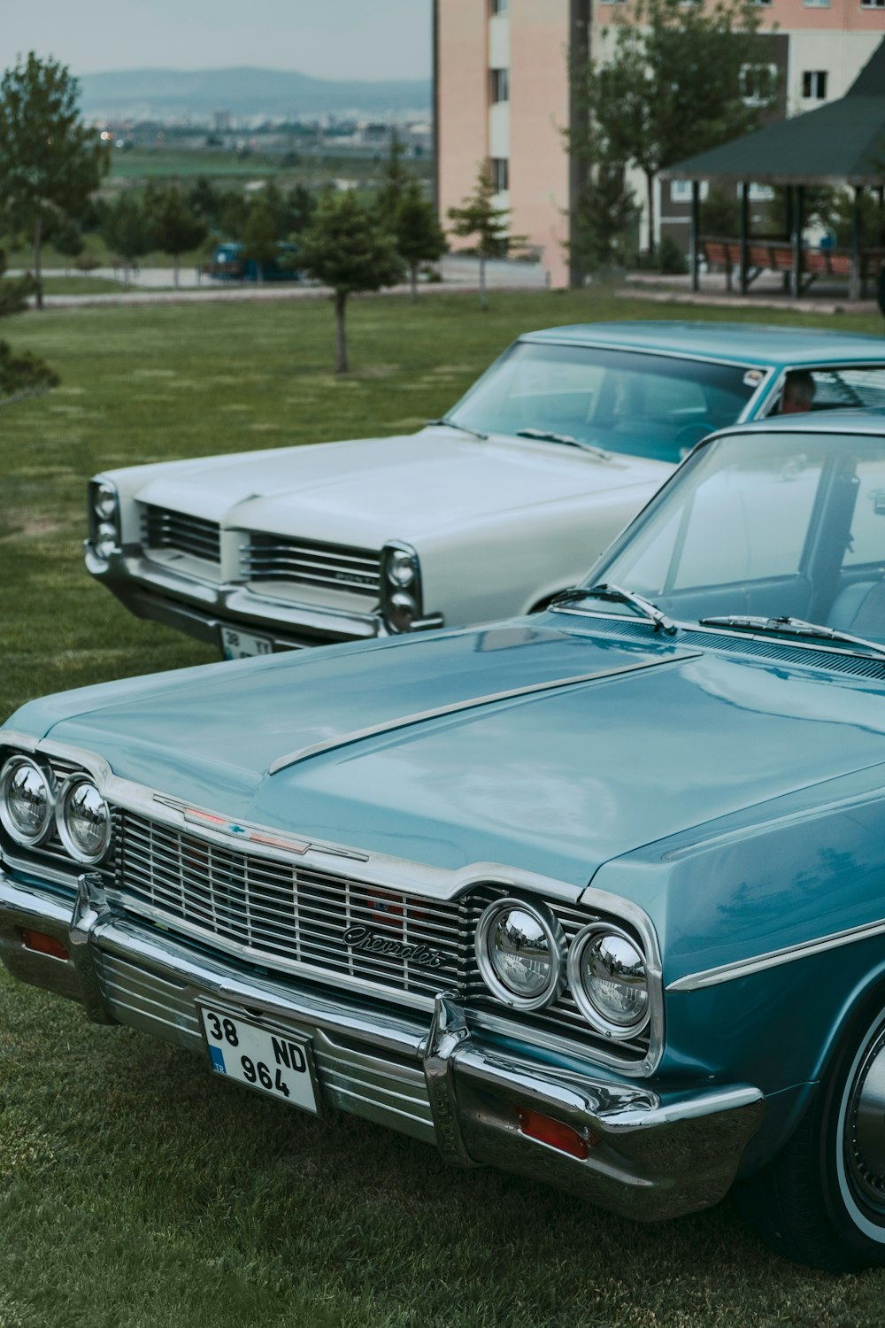 a couple of cars parked next to each other on a field