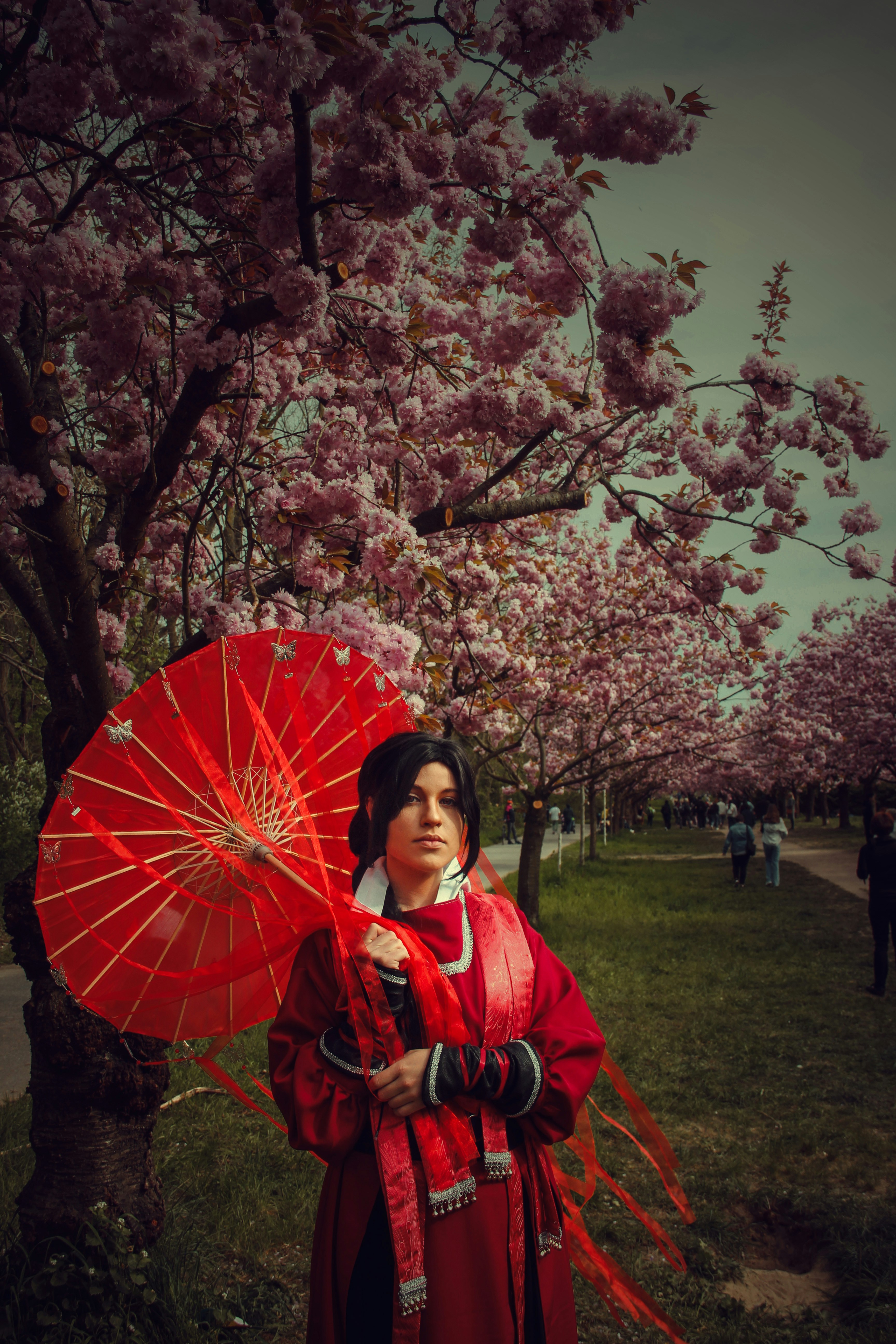 Seorang wanita dengan kimono merah memegang payung merah