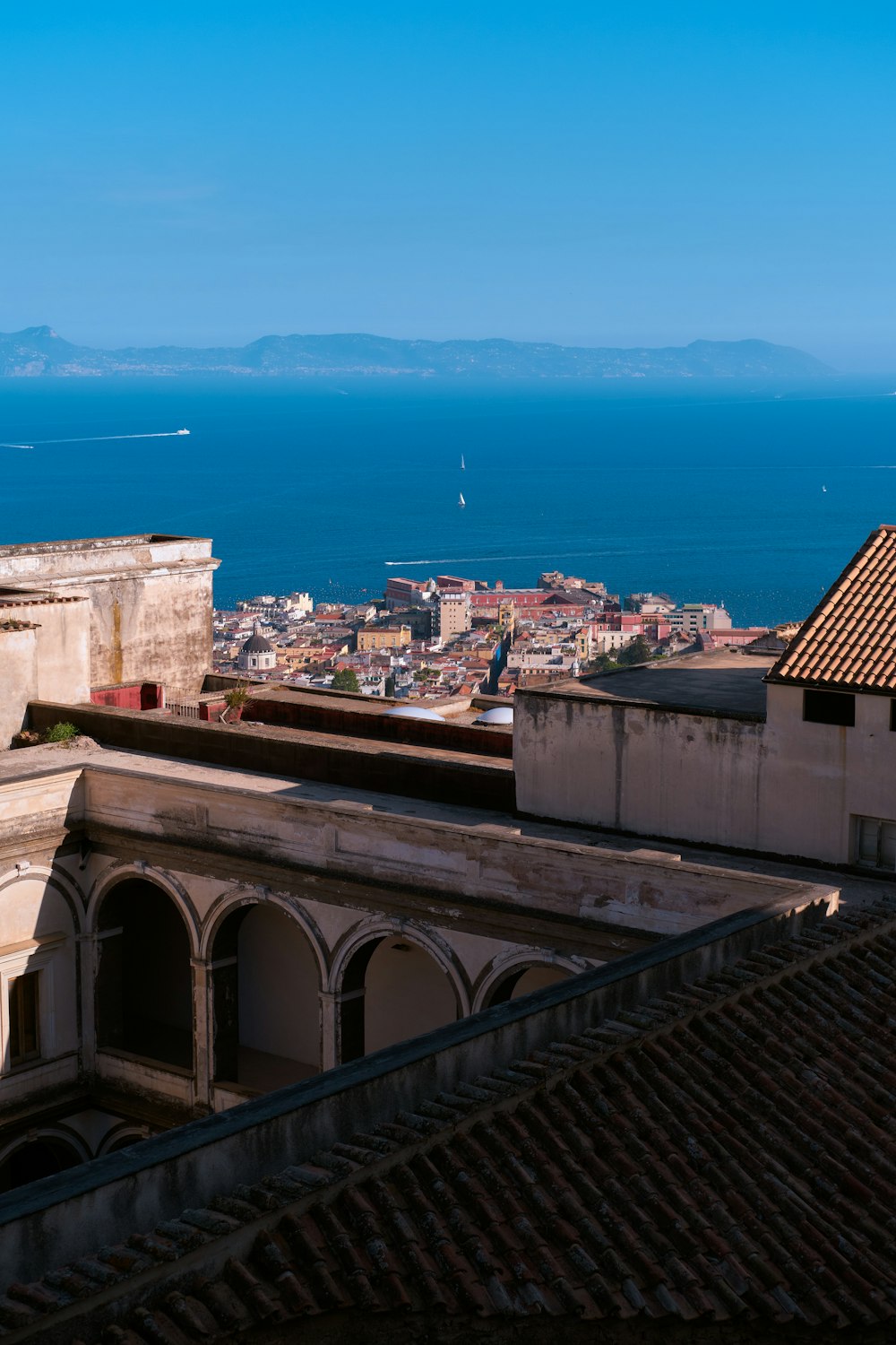 Una vista di una città e dell'oceano da un tetto