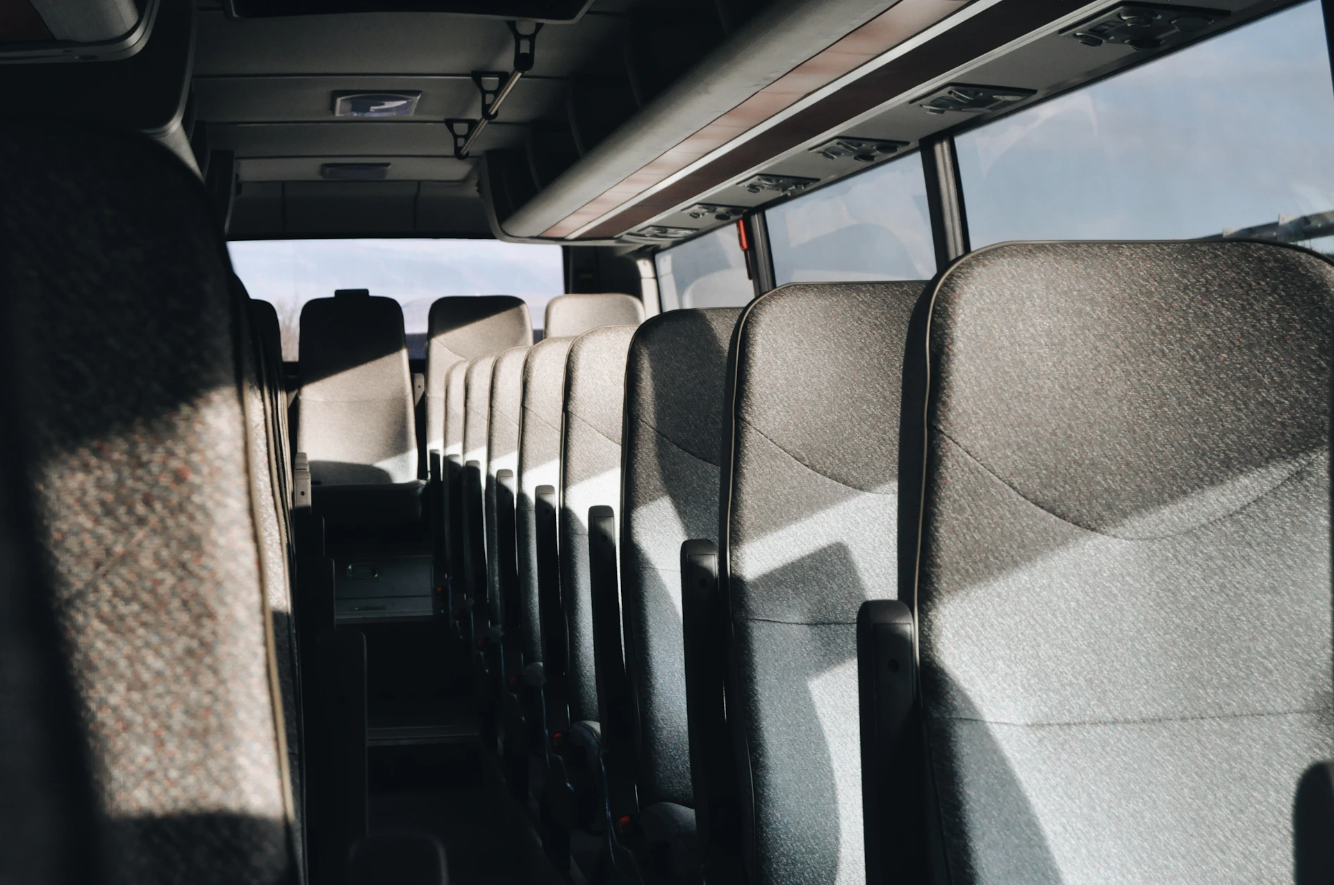 a row of seats in a bus with a sky background