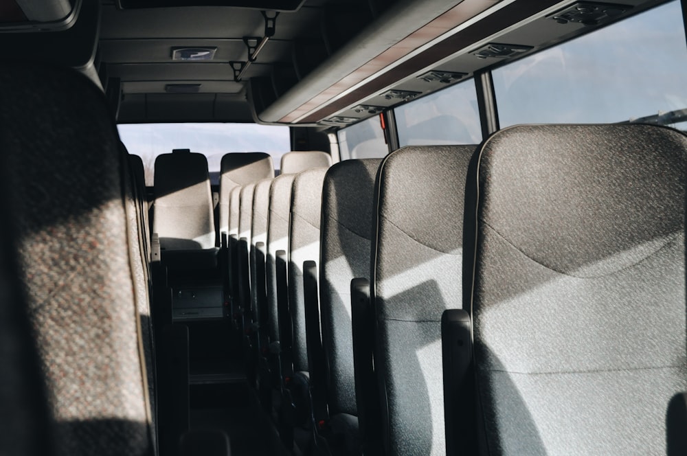 a row of seats in a bus with a sky background