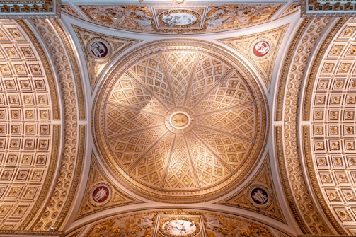 Close-up of a detailed ceiling design featuring gold accents and smooth finishes.