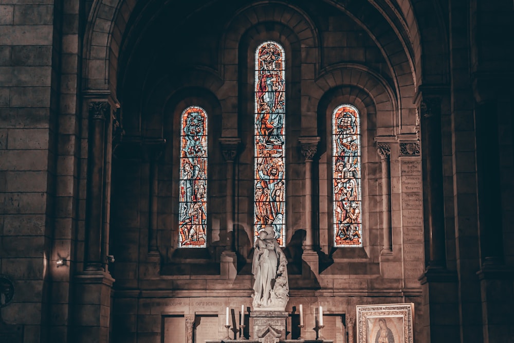 a church with a statue of an angel in front of a stained glass window