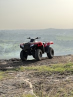 a red four wheeler parked on a dirt road