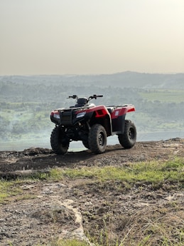 a red four wheeler parked on a dirt road