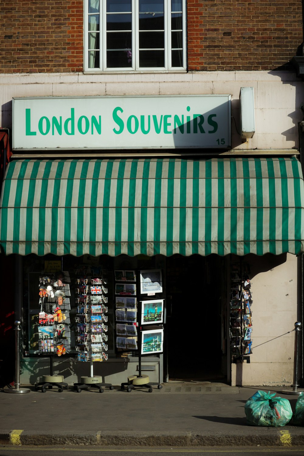 a london souvenirs store with a green and white awning