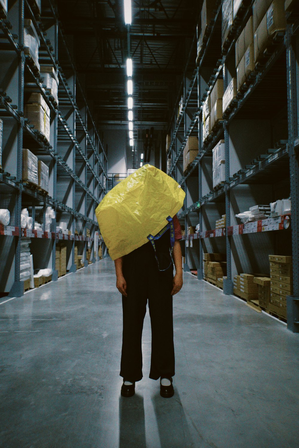 a person holding a yellow umbrella in a warehouse