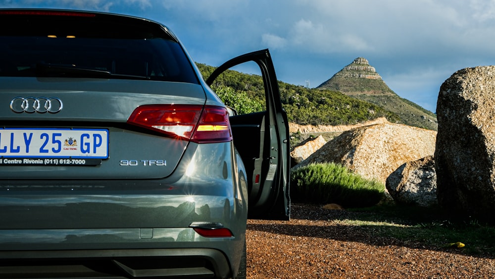 a car parked in front of a large rock formation