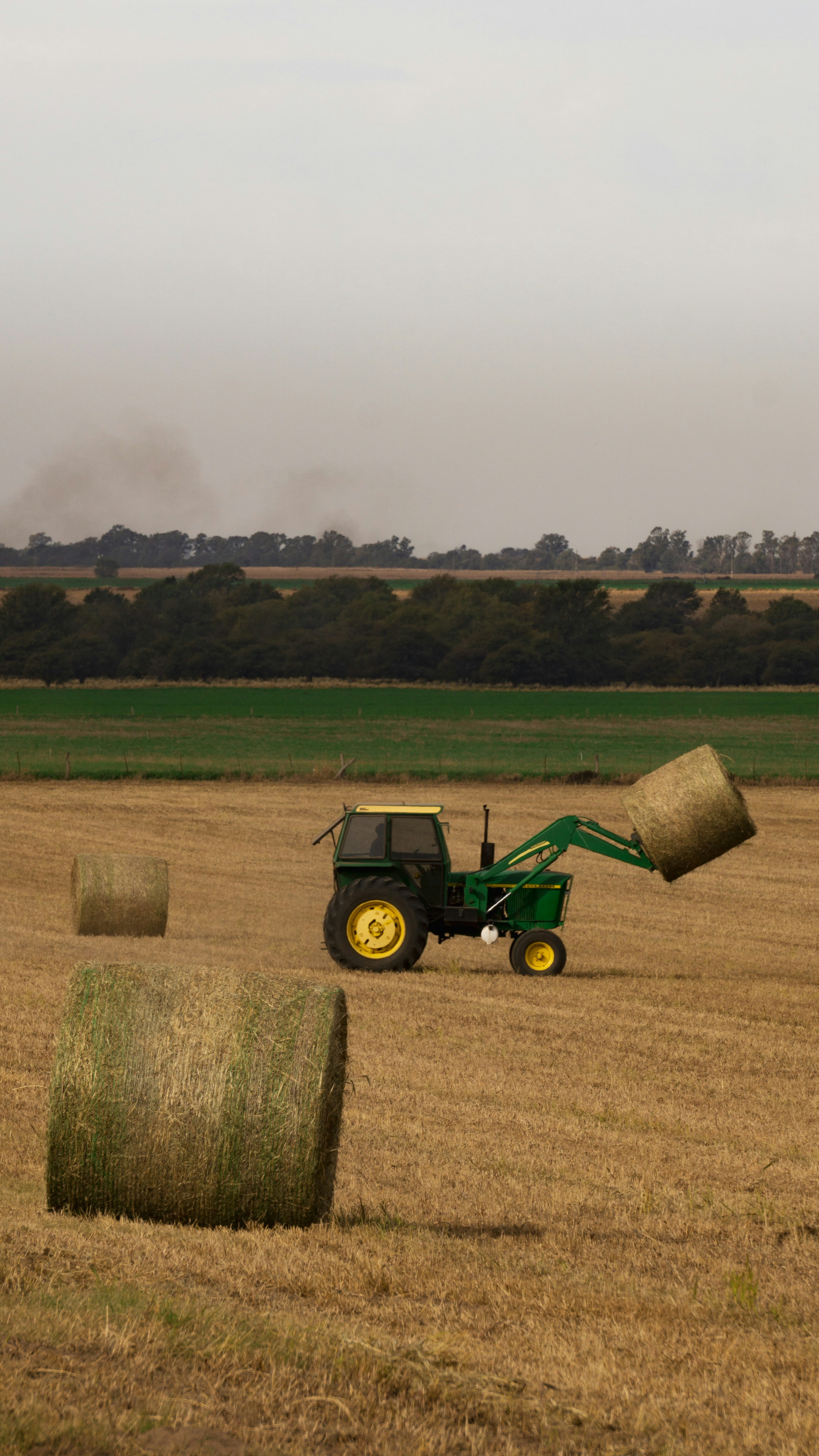 a tractor and hay bales in a field