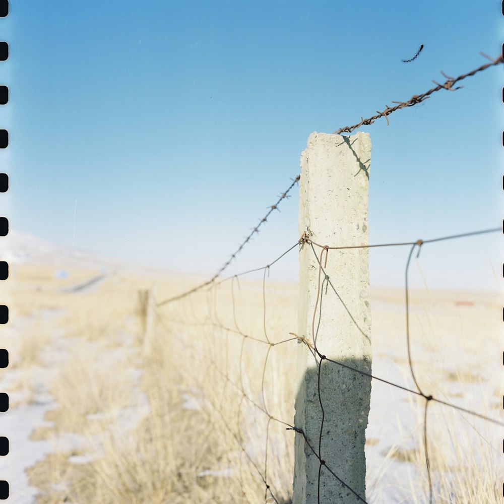 a barbed wire fence in a snowy field