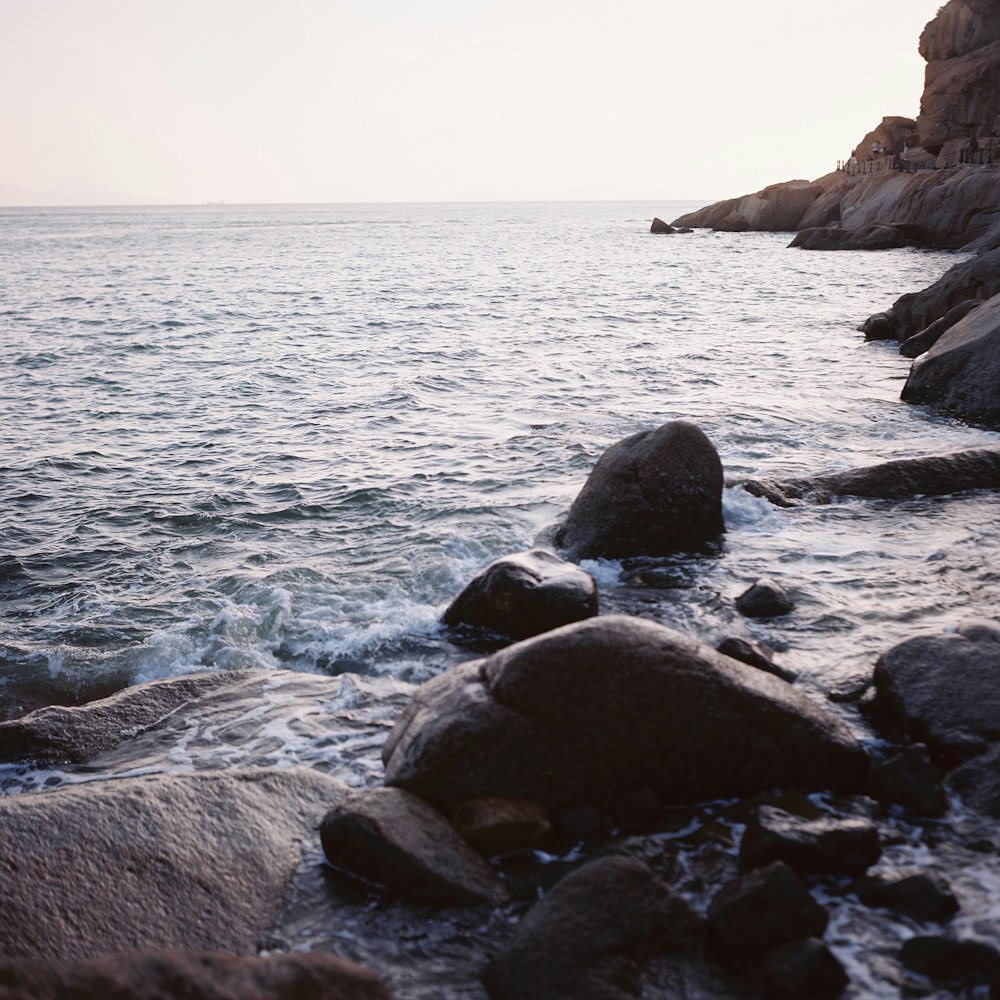 a body of water sitting next to a rocky shore
