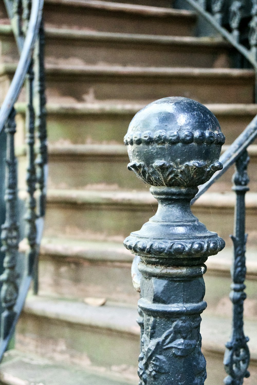 a close up of a metal railing near a set of stairs