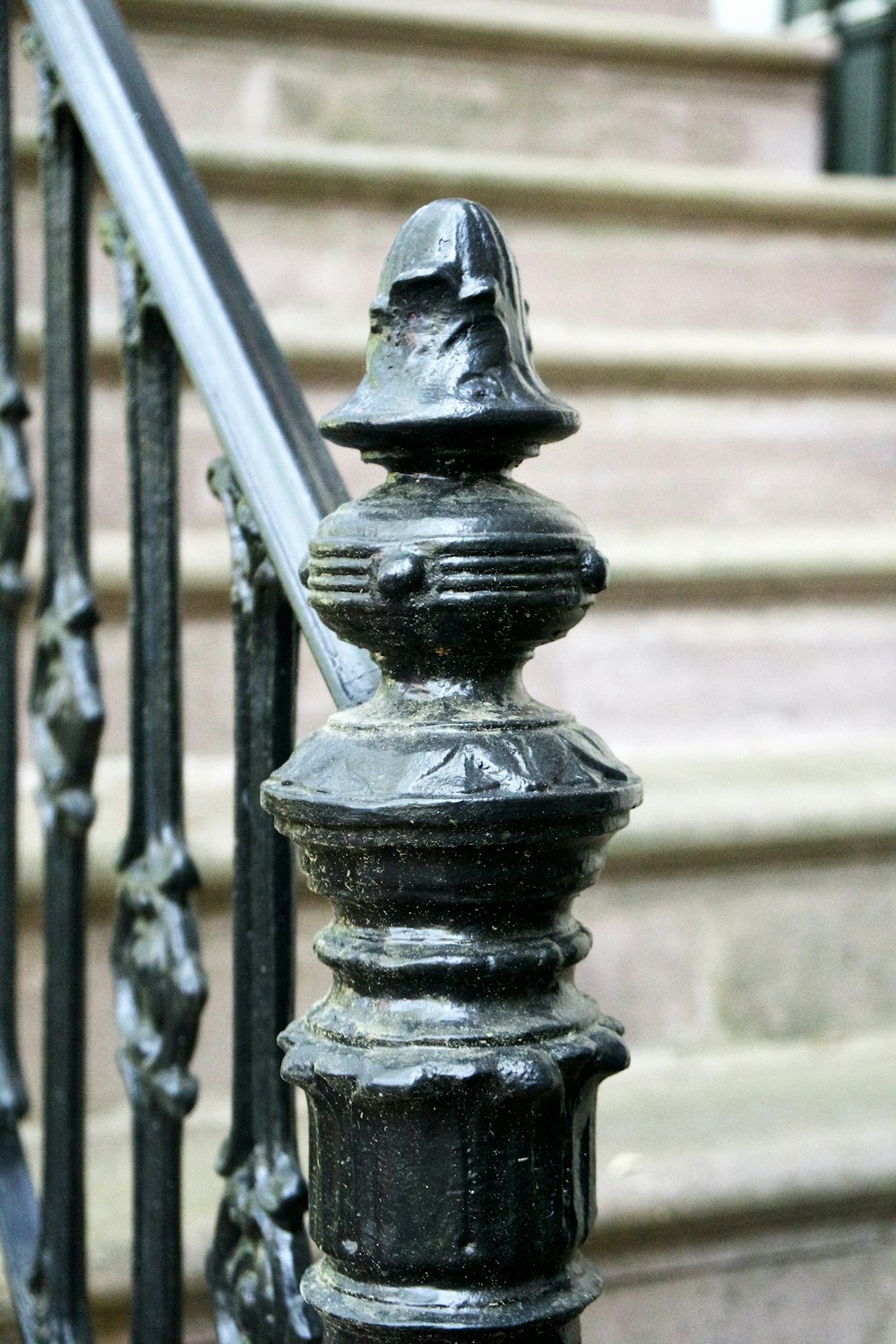 a close up of a metal railing with steps in the background