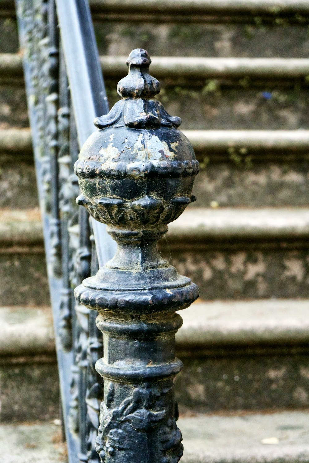 a close up of a metal railing near a set of stairs