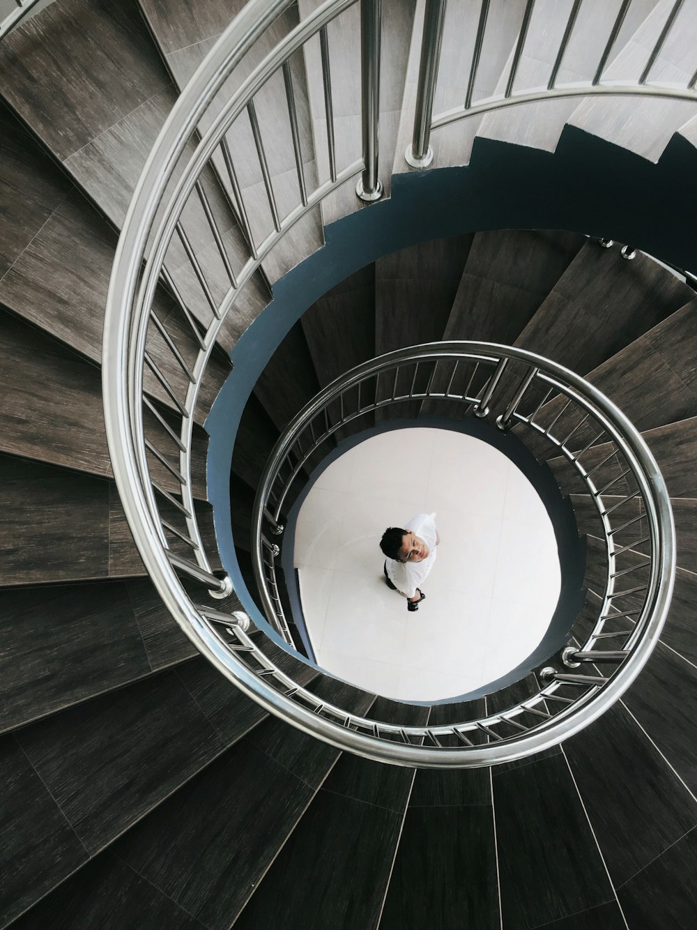 a man is standing on a spiral staircase