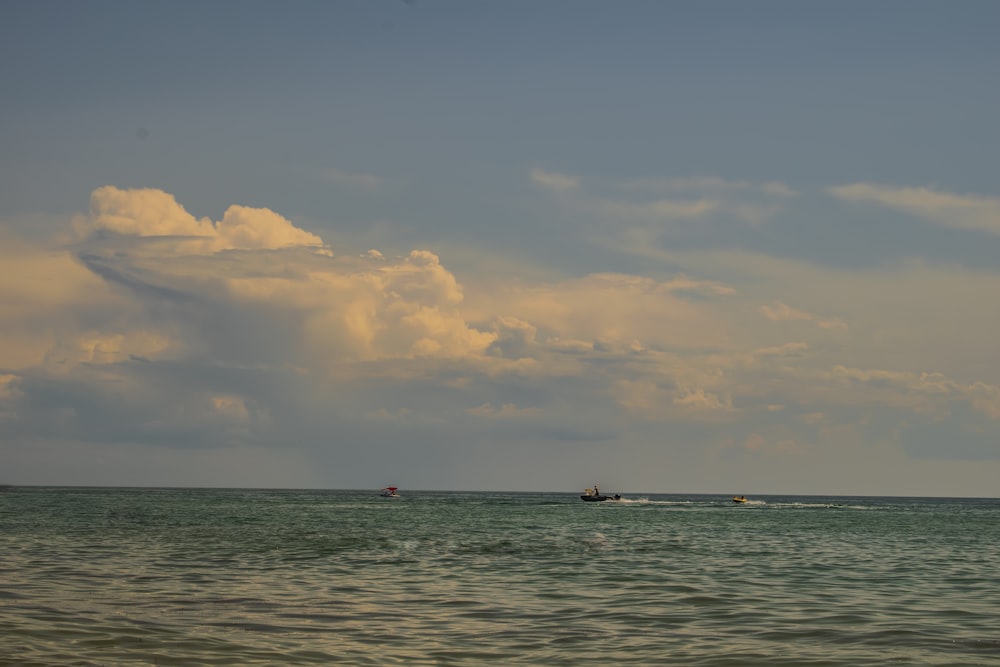 a couple of boats floating on top of a large body of water