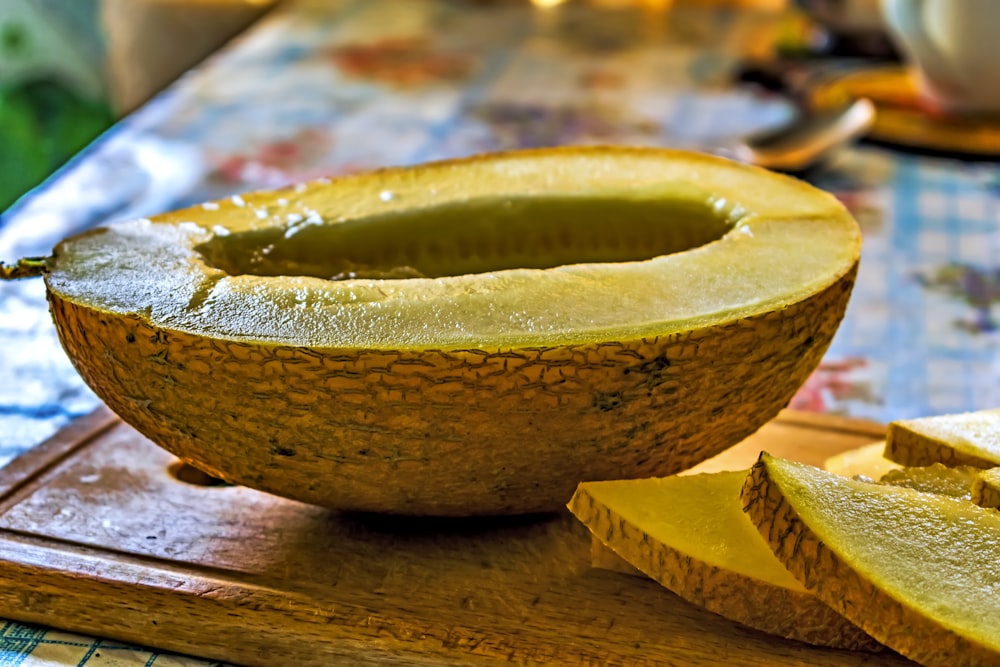 a melon is cut in half on a cutting board