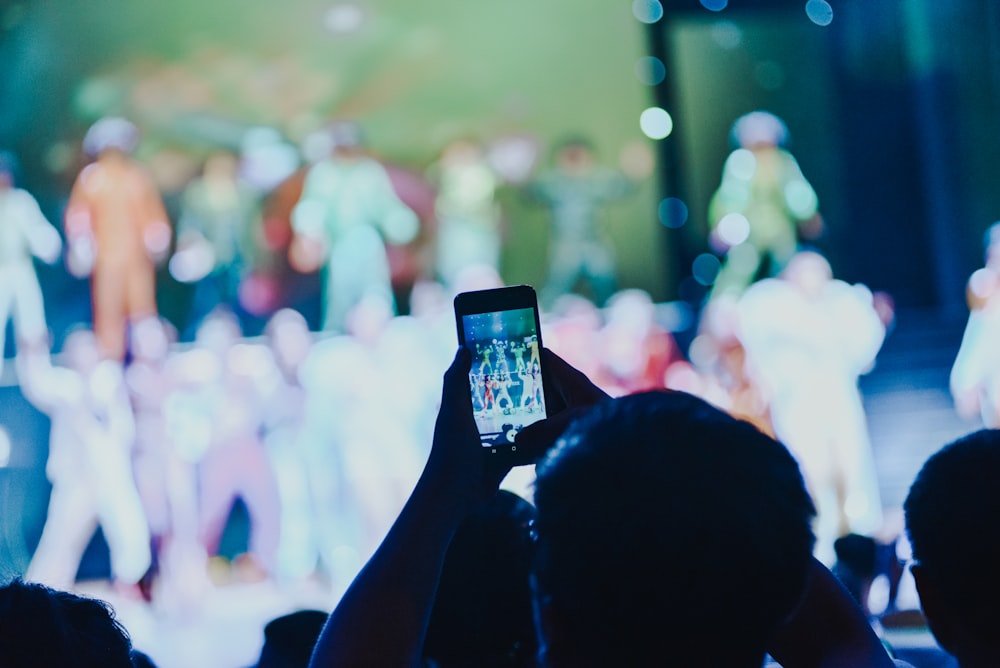 a person taking a picture of a group of people on a stage