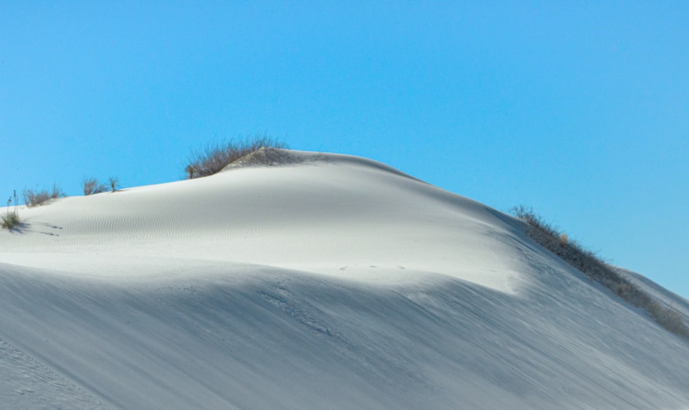 a person riding a snowboard down a snow covered slope