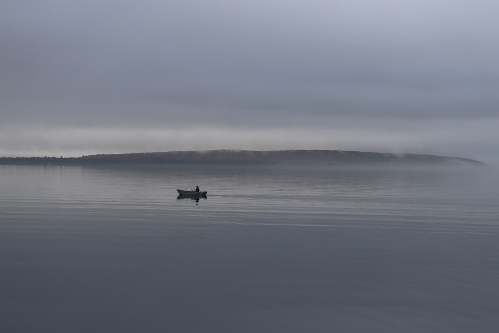 a person in a small boat on a large body of water