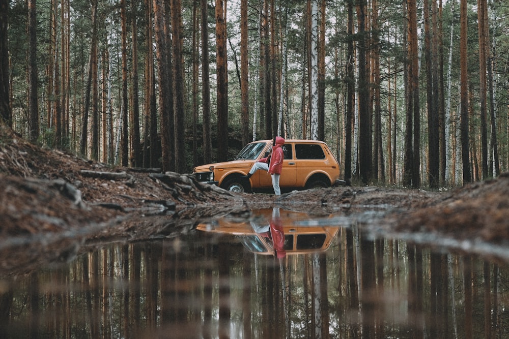 a yellow truck parked in the middle of a forest