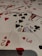 A pile of playing cards scattered across a surface, displaying a variety of suits including hearts, spades, diamonds, and clubs. Visible cards include numbers and a portion of a face card.