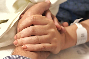 a close up of a person holding the hand of another person