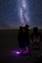 a couple of people standing next to each other under a sky filled with stars