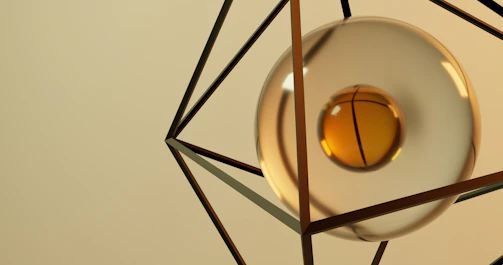 A smooth rotating sphere balanced on an inverted pyramid atop a cube, set against a warm beige background with soft cinematic lighting.