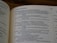 An open book displaying text, with visible page numbers and sections emphasizing poetry. The lighting creates a cozy atmosphere with shadows on the pages.