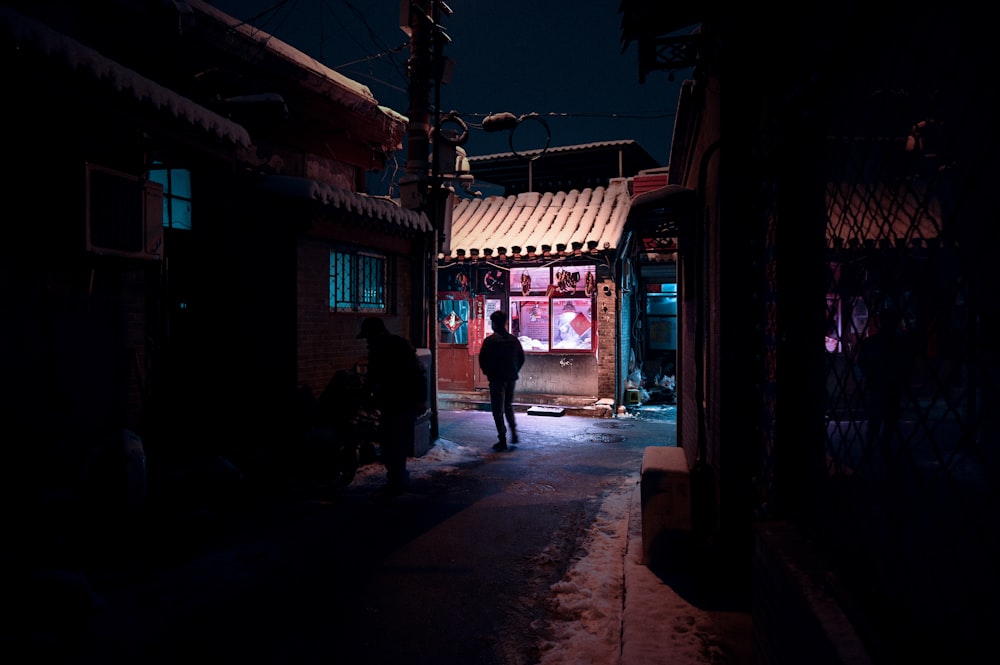 a man walking down a street at night
