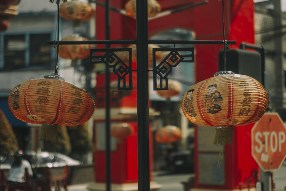 a couple of chinese lanterns hanging from a pole