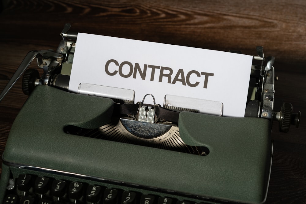 a close up of a typewriter with a sign that reads contact