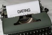 A vintage typewriter with a sheet of paper showing the words 'Save the Date' in cursive.