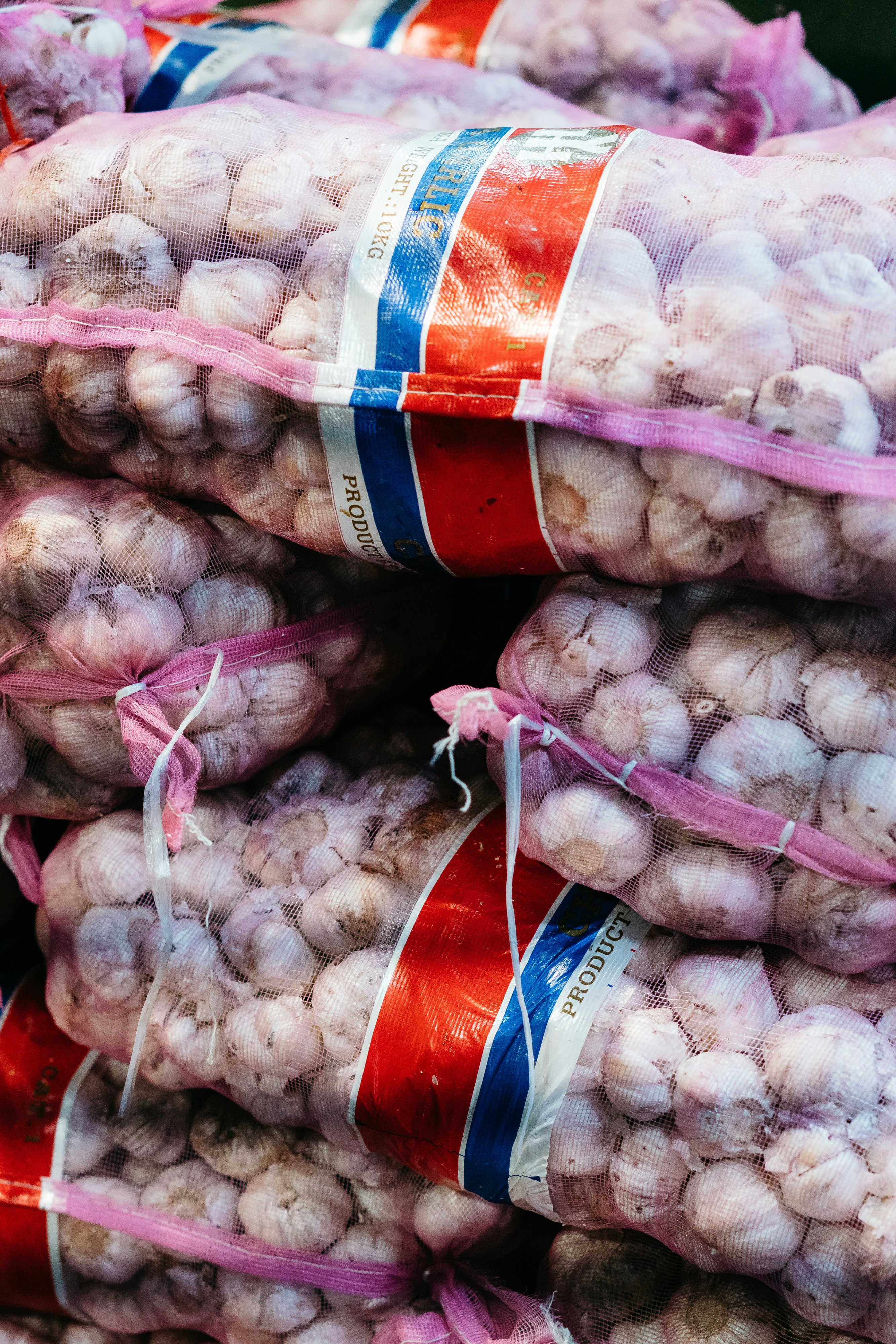 a pile of garlic sitting on top of a pile of bags