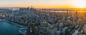 A panoramic view of a city skyline taken from a drone during golden hour, emphasizing real estate potential.