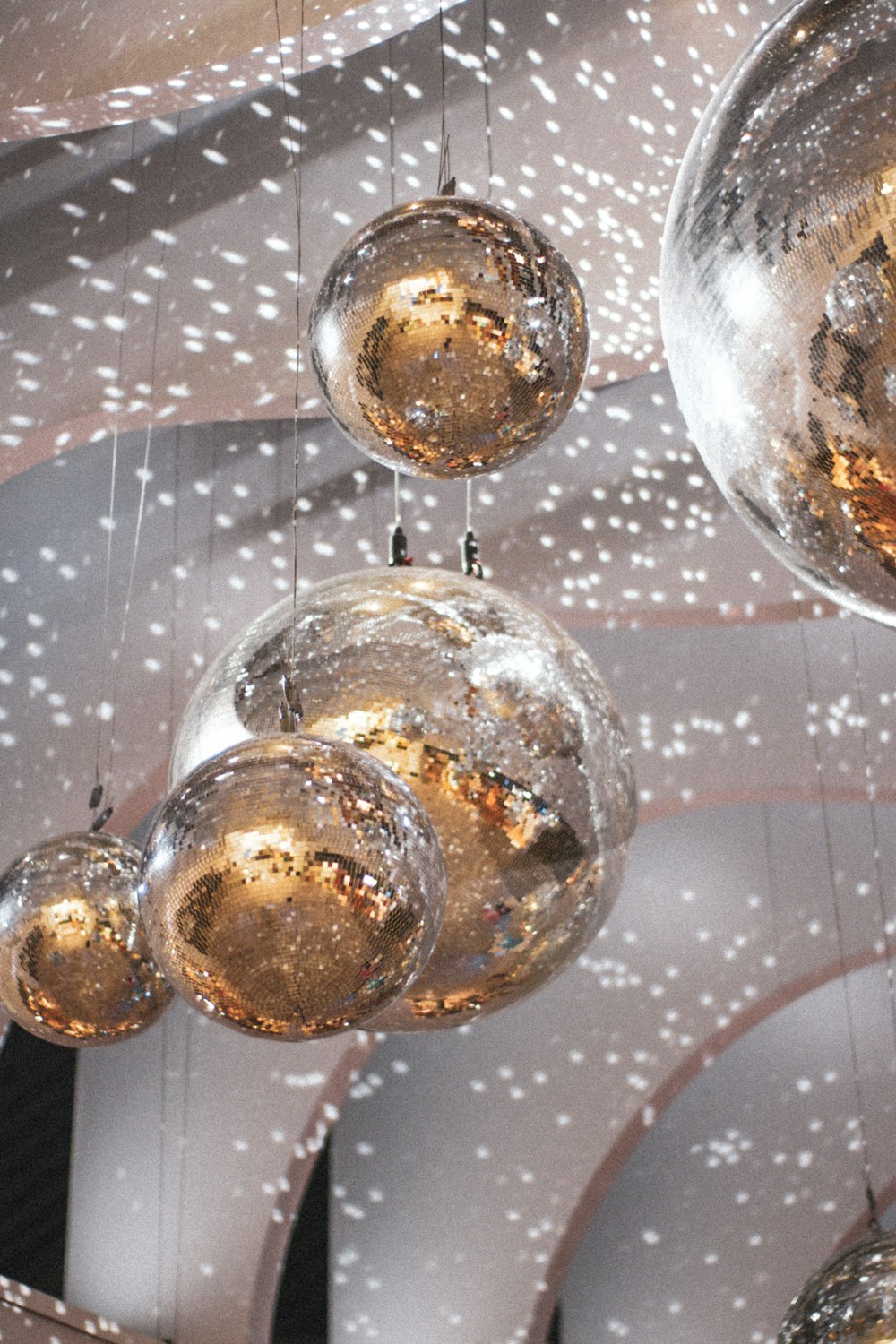 a bunch of shiny balls hanging from a ceiling