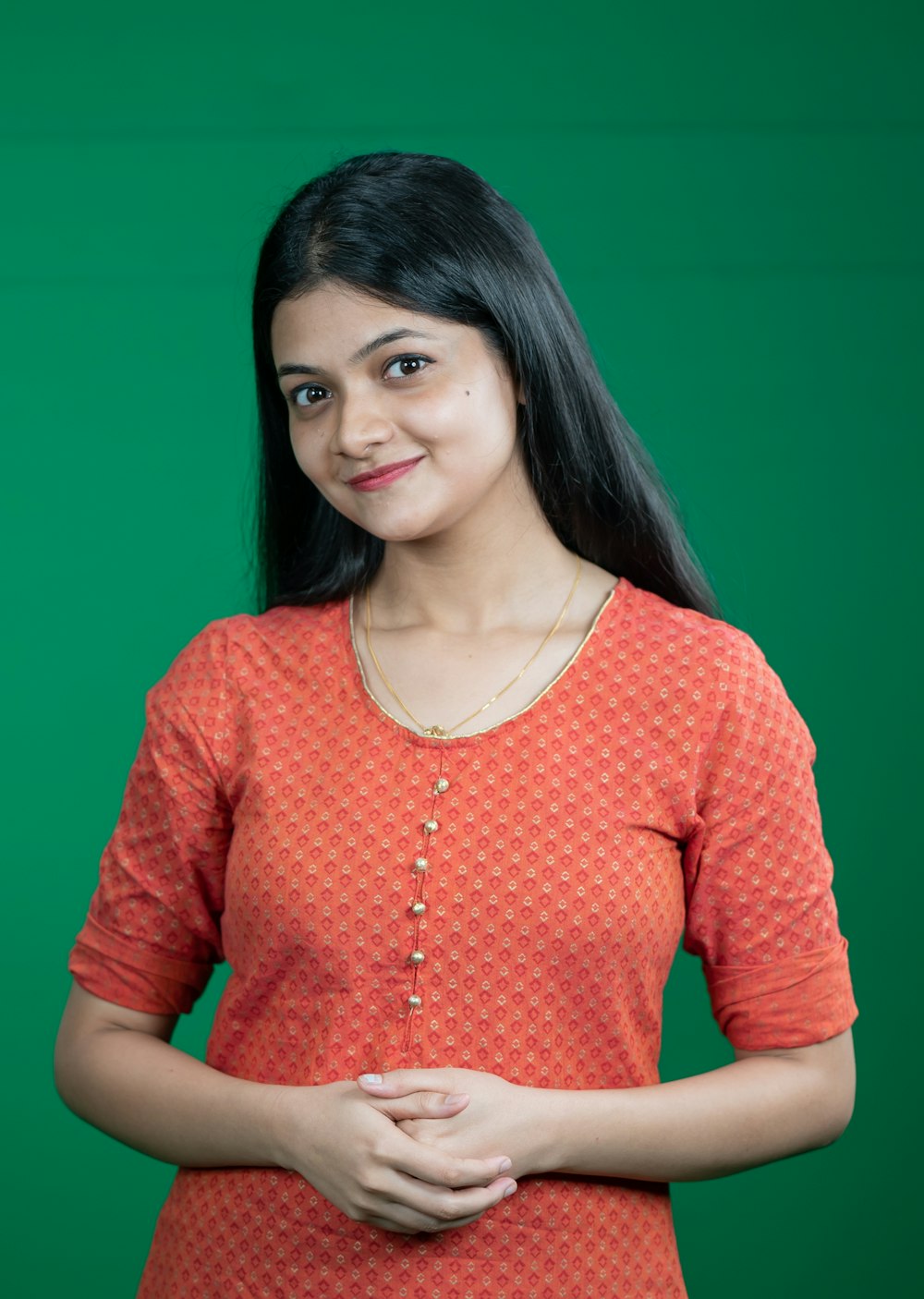 a woman standing in front of a green background