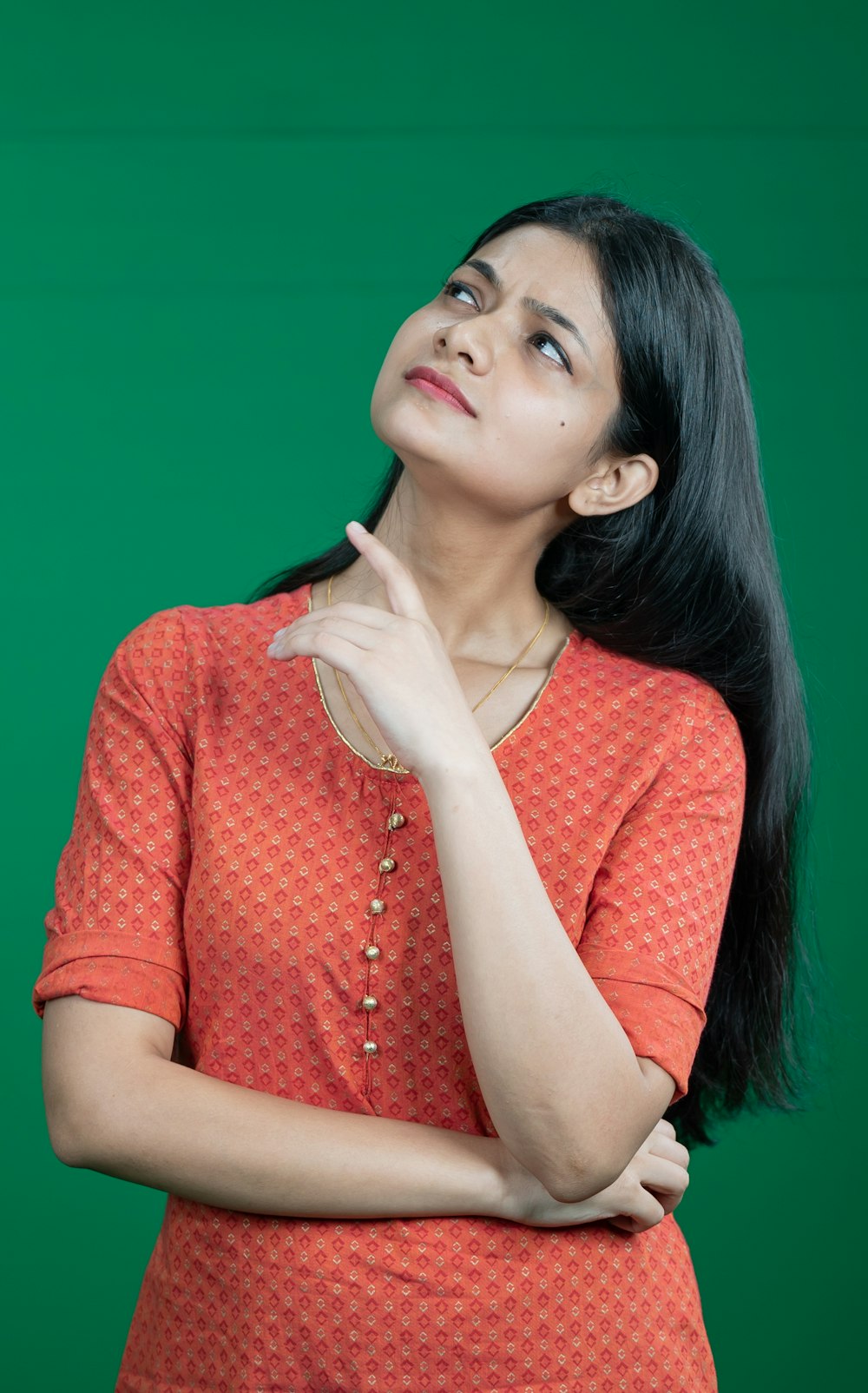 a woman in an orange top is looking up