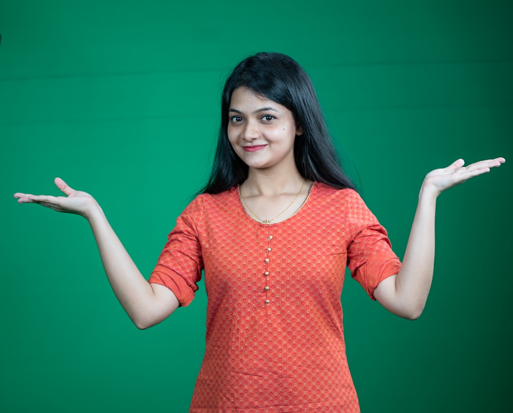 a woman holding out her hands in front of a green background
