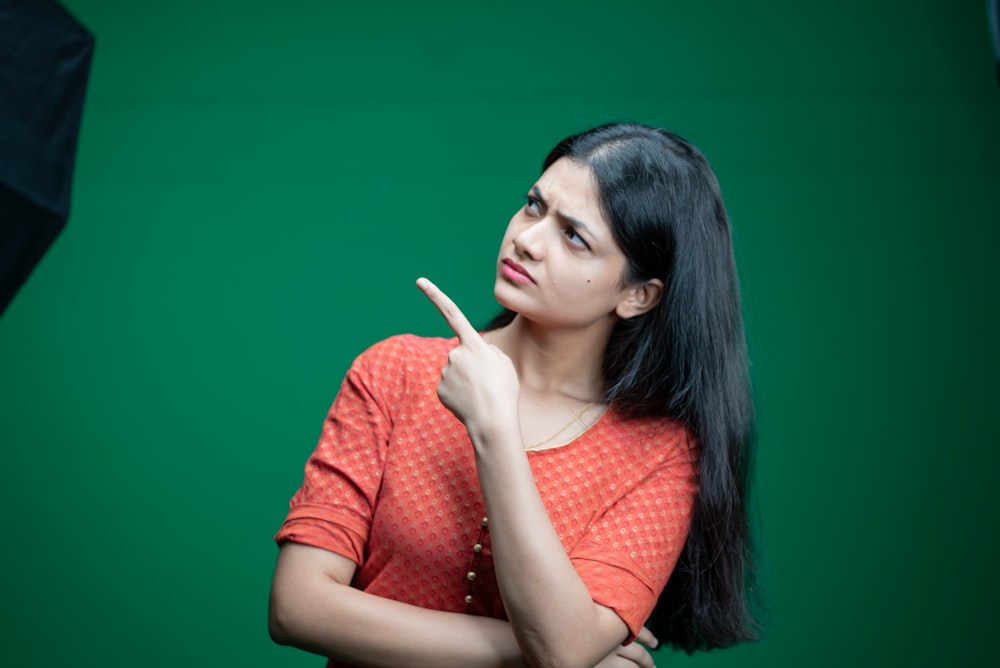 a woman standing in front of a green screen