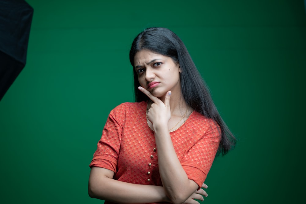 a woman standing in front of a green background